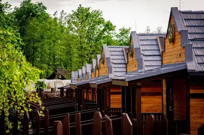 a row of wooden homes with roofs on them at Western Camp Resort in Zator
