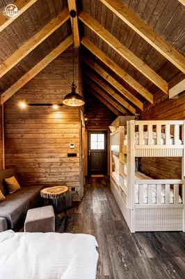 a bedroom with bunk beds in a wooden cabin at Western Camp Resort in Zator