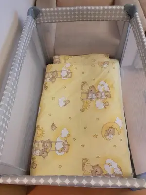 a crib with a blanket with animals on it at Aquapark by JoApart - with underground garage box in Kraków