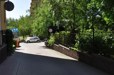 a car driving down a street next to a fence at Aquapark by JoApart - with underground garage box in Kraków