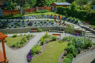 a garden with benches and plants and a waterfall at Hotel Wiosna in Rabka