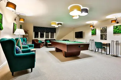 a living room with a pool table and chairs at Hotel Wiosna in Rabka