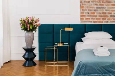 a bedroom with a bed and a vase with flowers at STRADOMSKA 2 APARTMENTS in Kraków