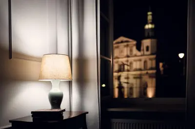 a lamp sitting on a table next to a window at STRADOMSKA 2 APARTMENTS in Kraków