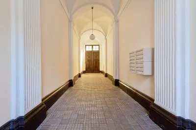 an empty hallway with a door and a tile floor at Apartamenty Pod Aniołami in Kraków