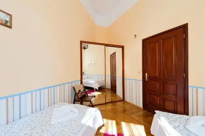 a room with two beds and a mirror at Apartamenty Pod Aniołami in Kraków