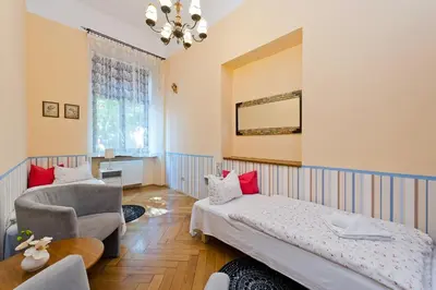 a bedroom with a bed and a chair at Apartamenty Pod Aniołami in Kraków