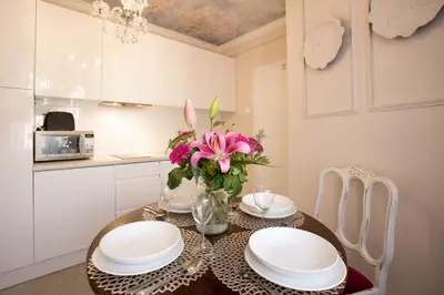 a dining room table with plates and a vase of flowers at Antique Apartments Old Town in Kraków