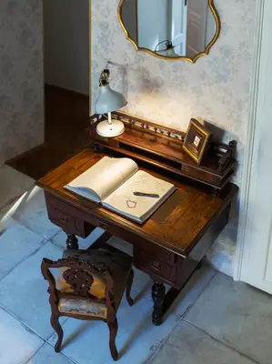 a wooden desk with a mirror and a lamp on it at Antique Apartments Old Town in Kraków