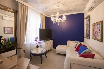 a living room with a couch and a tv at Antique Apartments Old Town in Kraków