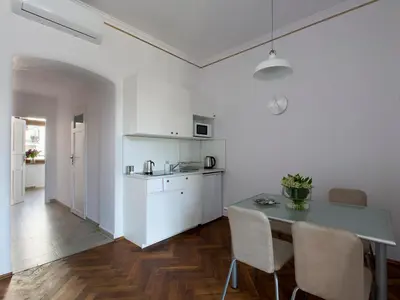 a kitchen and dining room with a table and chairs at Antique Apartments Old Town in Kraków