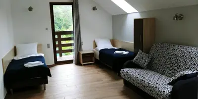 a room with two beds and a couch and a window at Przy Dolinie in Paczółtowice