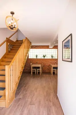 a room with a staircase and a table and chairs at Przy Dolinie in Paczółtowice