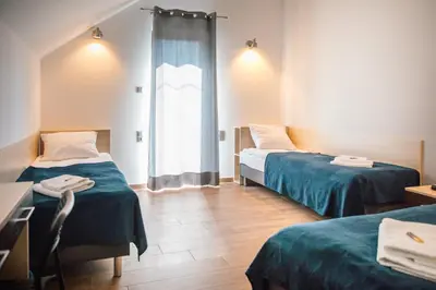 a room with two beds and a window at Przy Dolinie in Paczółtowice