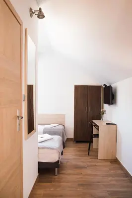 a bedroom with two beds and a desk in it at Przy Dolinie in Paczółtowice