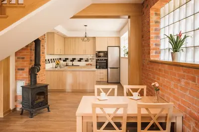 an open kitchen and dining room with a brick wall at Przy Dolinie in Paczółtowice