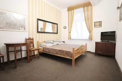 a bedroom with a bed and a table and a television at Da Vinci Apartment in Kraków