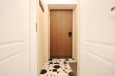 a hallway with a door with a black and white floor at Da Vinci Apartment in Kraków