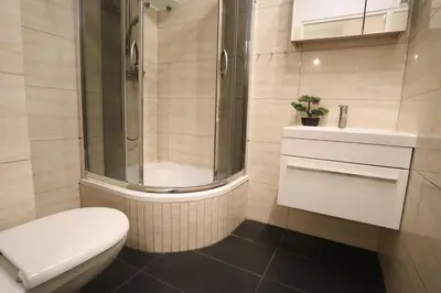 a bathroom with a shower and a toilet and a sink at Da Vinci Apartment in Kraków