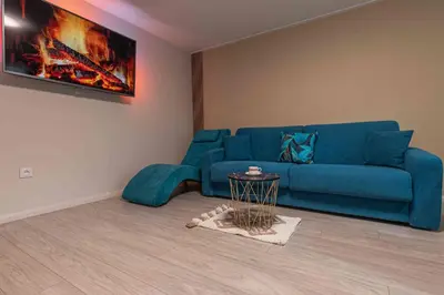 a living room with a blue couch and a table at Apartament Komfort przy Parku Zdrojowym in Rabka