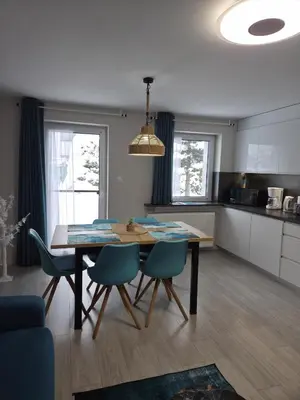 a kitchen and dining room with a table and chairs at Apartament Komfort przy Parku Zdrojowym in Rabka