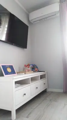 a room with a white dresser with a tv on the wall at Apartament Antek klimatyzowany in Oświęcim