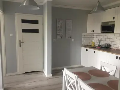 a kitchen with a table and a white door at Apartament Antek klimatyzowany in Oświęcim
