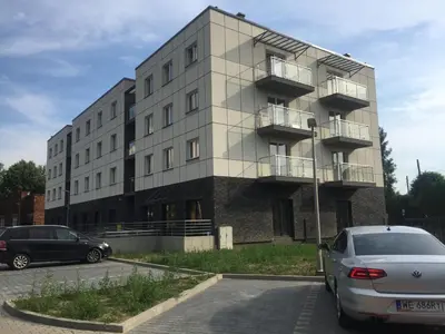 a building with cars parked in front of it at Apartament Antek klimatyzowany in Oświęcim