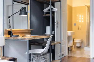 a desk with a chair and a lamp in a room at Straszewskiego 24 Boutique Apartments in Kraków