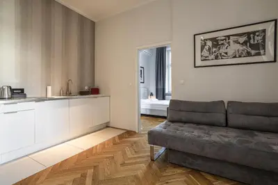 a living room with a couch and a kitchen at Straszewskiego 24 Boutique Apartments in Kraków