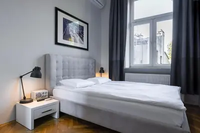 a bedroom with a white bed and a window at Straszewskiego 24 Boutique Apartments in Kraków