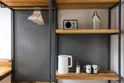 a kitchen with wooden shelves and a wall with black tile at Straszewskiego 24 Boutique Apartments in Kraków
