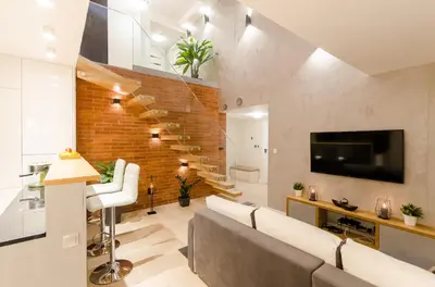 a living room with a couch and a tv and a brick wall at Central Penthouse with terrace in Kraków