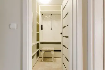 a walk in closet with a bench and a stool at Central Penthouse with terrace in Kraków