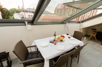 a dining room with a white table and chairs at Central Penthouse with terrace in Kraków