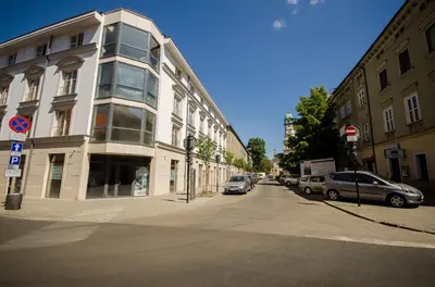 a building on a street with cars parked next to it at Central Penthouse with terrace in Kraków