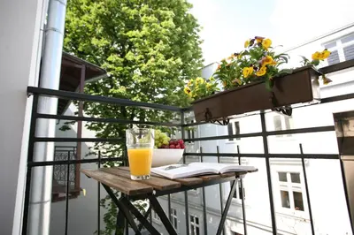 a glass of orange juice sitting on a table on a balcony at AS Smart Apartment Old Town Krakow in Kraków