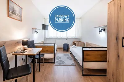 a room with a bed and a desk and a table at Hotel Alf in Kraków
