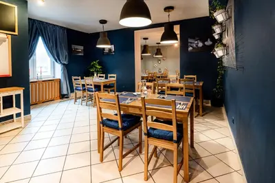 a dining room with a table and chairs at Hotel Alf in Kraków