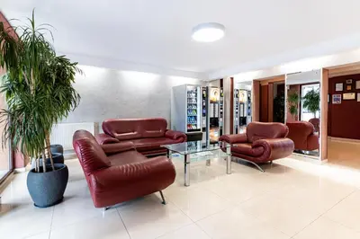 a waiting room with leather chairs and a table at Hotel Alf in Kraków
