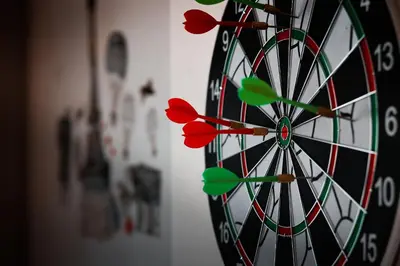 a dartboard with red darts in the middle at Hotel Alf in Kraków