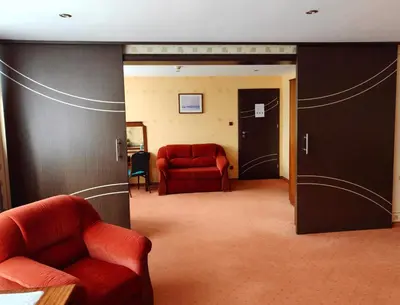a room with a red couch and a red chair at Hotel Alf in Kraków