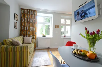 a living room with a table and a couch at Crystal Suites Chez Helena in Kraków