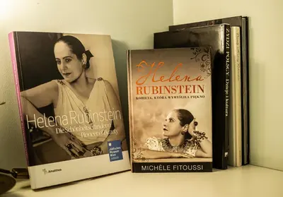 three books sitting on top of a shelf at Crystal Suites Chez Helena in Kraków