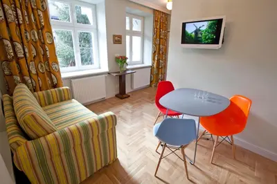 a living room with a couch and a table and chairs at Crystal Suites Chez Helena in Kraków