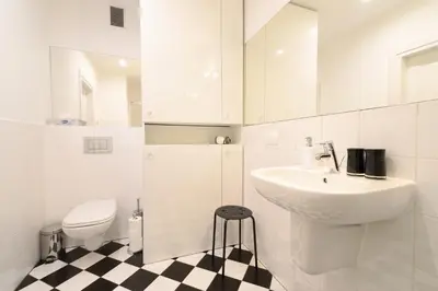 a white bathroom with a sink and a toilet at Crystal Suites Chez Helena in Kraków