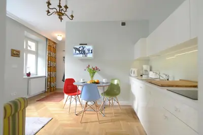 a kitchen with a table and chairs in a room at Crystal Suites Chez Helena in Kraków