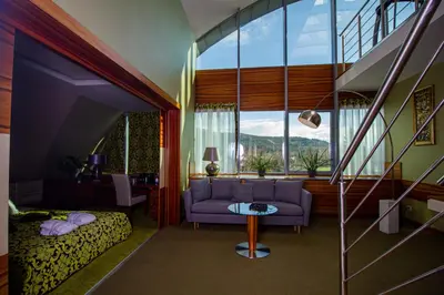 a bedroom with a couch and a bed and a window at Młyn Jacka Hotel & Spa in Wadowice