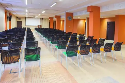 a conference room with chairs and a screen in the middle at Młyn Jacka Hotel & Spa in Wadowice