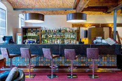 a bar with purple chairs in a room at Młyn Jacka Hotel & Spa in Wadowice